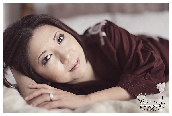 Beauty in a Kimono. Boudoir Photography by Rayleigh. This is an image of an Asian woman lying on her tummy on the bed. For more info, visit byrayleigh.com