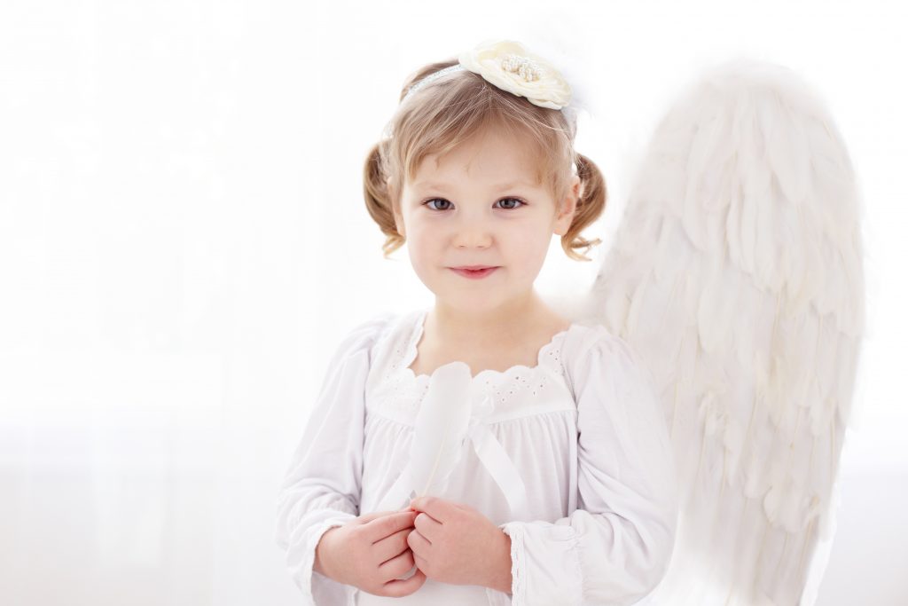 What to wear for a winter photo shoot in Portland. This is a backlit image of a young girl dressed as an angel for a Christmas photo shoot. Photography by Rayleigh. byRayleigh.com