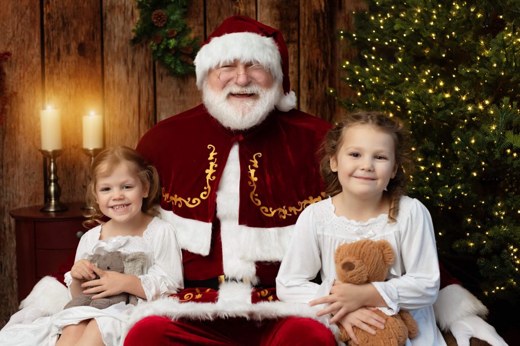 Santa Sessions in Portland, Oregon. Experience the magic of Christmas. These children are posed smiling with Santa during their photo shoot.