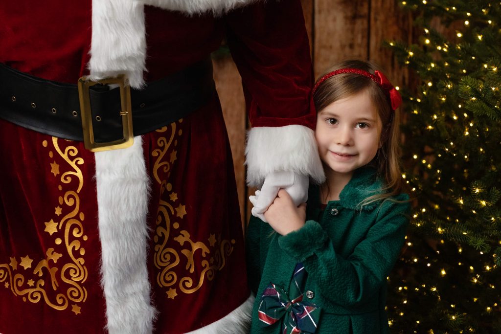 Santa Sessions in Portland, Oregon.. Experience the magic of Christmas. This child is holding Santa's hand for this photo shoot.