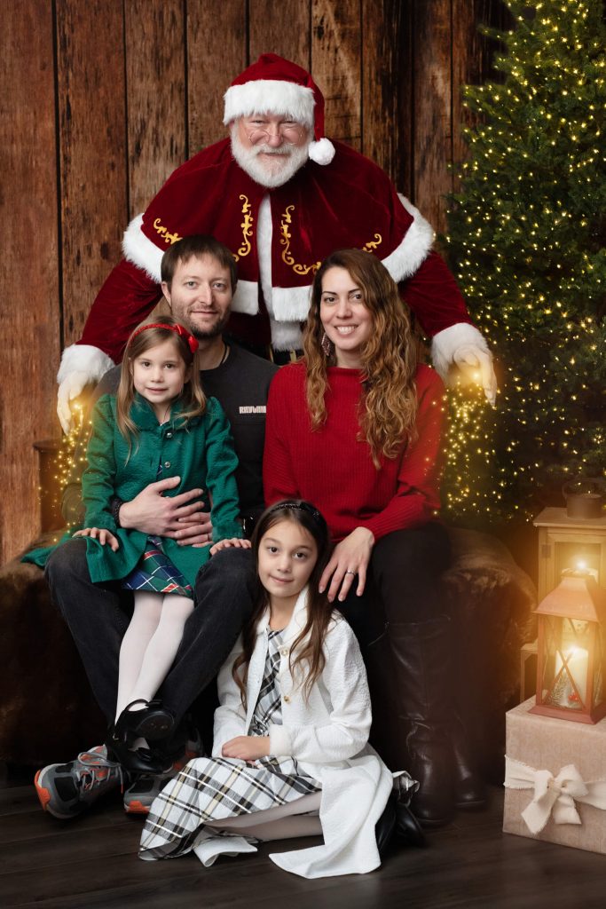 Santa Sessions in Portland, Oregon. Experience the magic of Christmas. A family portrait with Santa during the photo shoot.