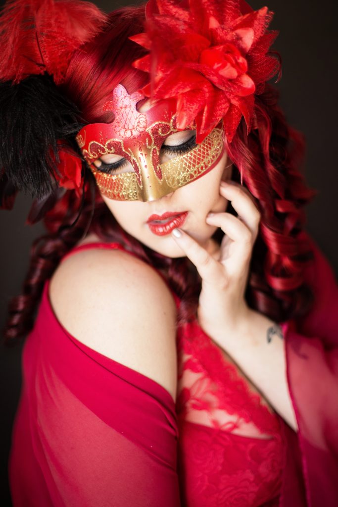 A valentine's day gift idea. Portland boudoir Photographer, Photography by Rayleigh. This woman is wearing all red and has red hair, which was a creative theme for this photo shoot.