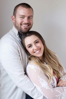 A studio couples photo shoot in Portland, OR. This is a sitting pose with a white background.
