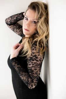 A boudoir photo shoot in a studio in Portland, OR. This is a standing pose against a wall.