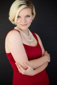 A beauty photo shoot in a studio in Portland, OR. This is a standing pose against a black backdrop.