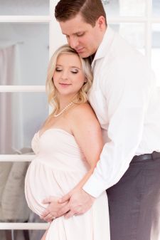 a studio couples maternity photo taken in Portland, OR. This is a standing pose in front of french doors.