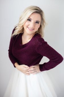 A beauty photo shoot in a studio in Portland, OR. This is a standing pose against a white backdrop.