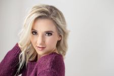 A beauty photo shoot in a studio in Portland, OR. This is a standing pose against a white backdrop.
