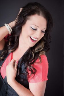 A beauty photo shoot in a studio in Portland, OR. This is a standing pose against a black backdrop.