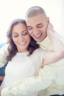 A studio engagement couples photo shoot in Portland, OR. This is a backlit photo with the couple sitting on a sofa.