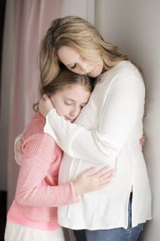 a studio family maternity photo taken in Portland, OR. A mother-daughter standing pose.