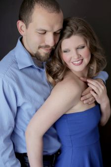 A studio couples engagement photo shoot in Portland, OR. This is a standing pose with a black background.