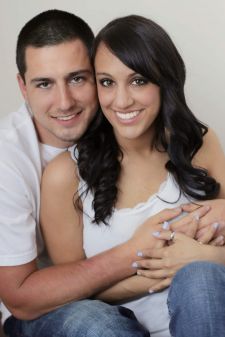 A studio couples photo shoot in Portland, OR. This is a sitting on the floor pose with a white background.