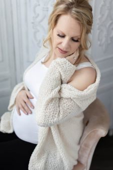 a studio boudoir maternity photo taken in Portland, OR. This is a sitting pose.