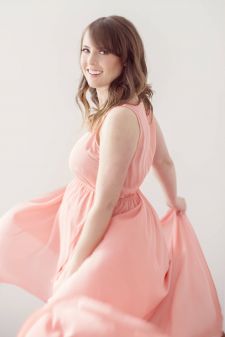 a studio maternity photo taken in Portland, OR. This is a motion standing pose with a flowy dress.