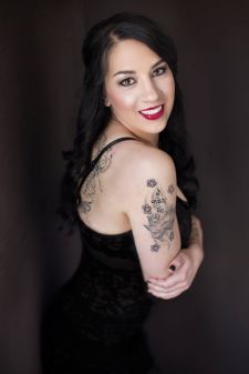 A boudoir photo shoot in a studio in Portland, OR. This is a standing wall pose against a black backdrop.