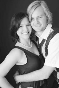 A studio couples photo shoot in Portland, OR. This is a standing pose with a black background.