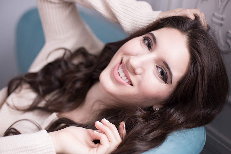 4 tips for choosing a Portland Senior photographer. This image is of a high school senior girl lying back on a couch.
