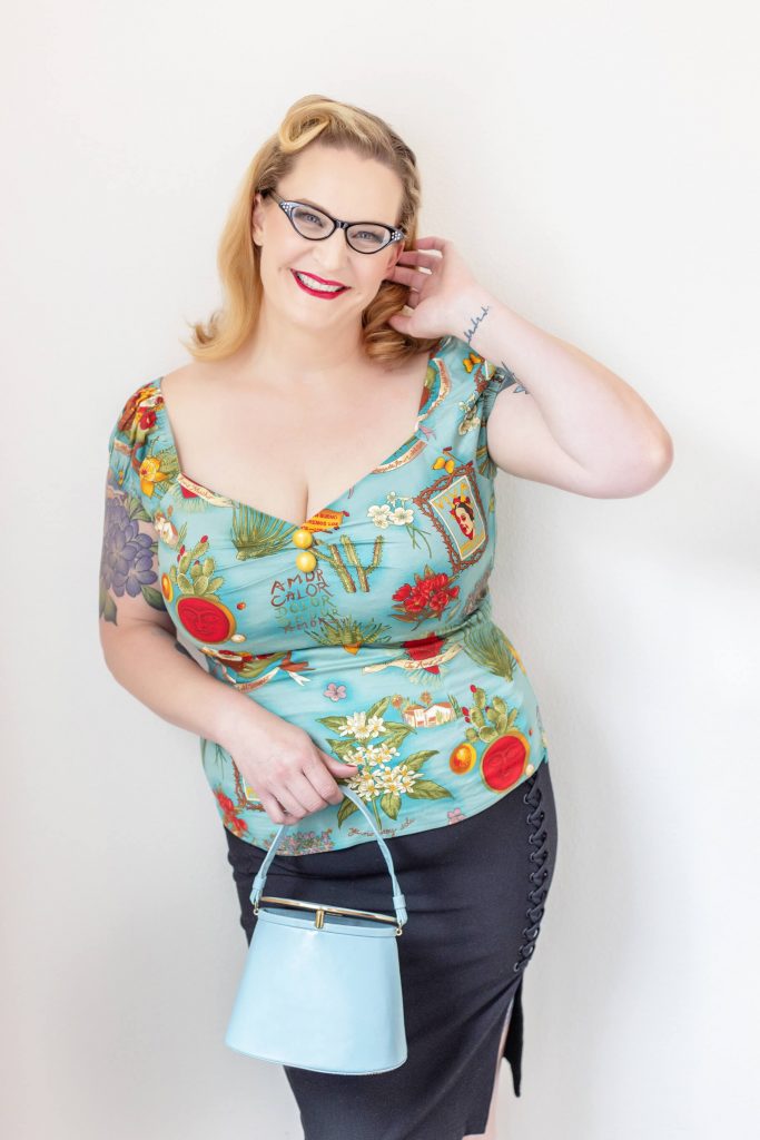A posed studio image from a pin up photo shoot experience in Portland. Props include a vintage blue purse.