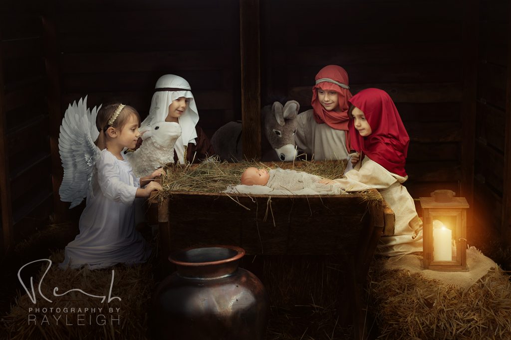 Photography by Rayleigh Christmas mini sessions - Nativity Portrait Experience. Mary, Joseph, a shepherd, and an angel gazing at baby Jesus in a manger. For more info, visit byRayleigh.com