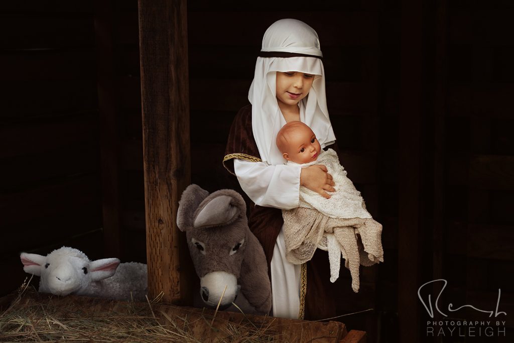 Photography by Rayleigh Christmas mini sessions - Nativity Portrait Experience. A shepherd holding baby Jesus in a stable. For more info, visit byRayleigh.com